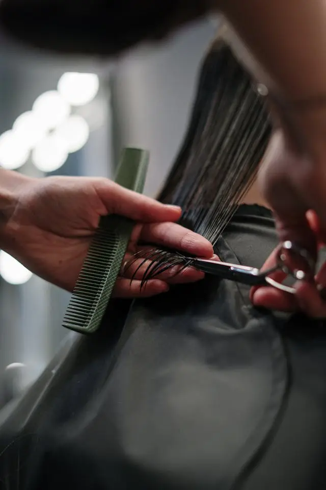 Hair stylist cutting the hair of a woman