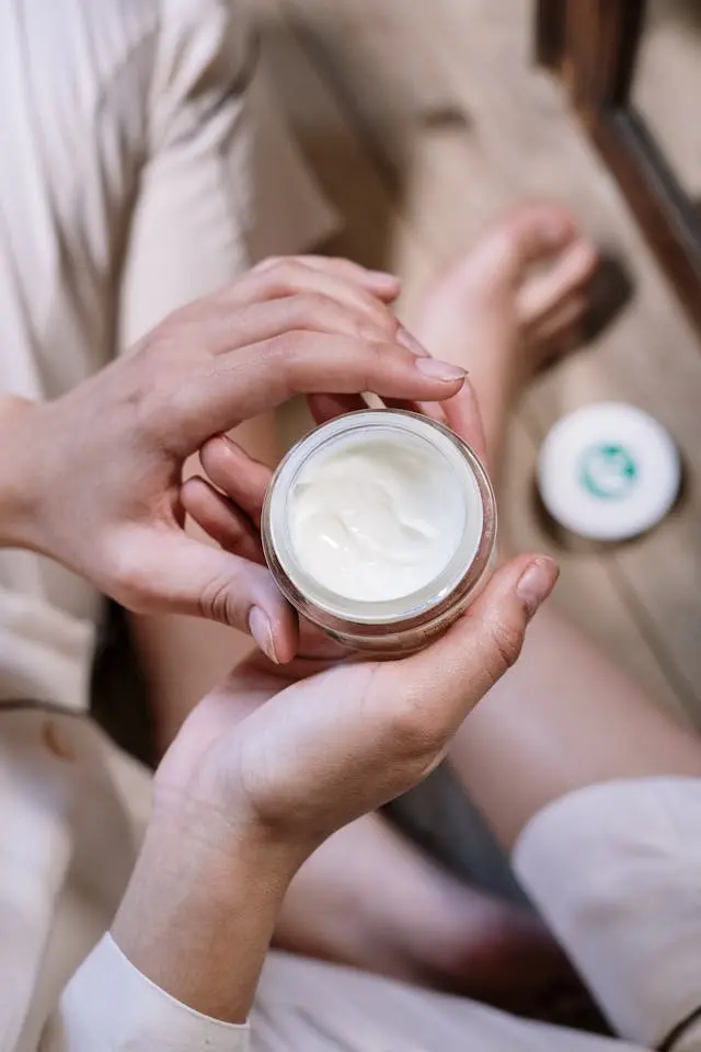Person holding a jar of skin cream