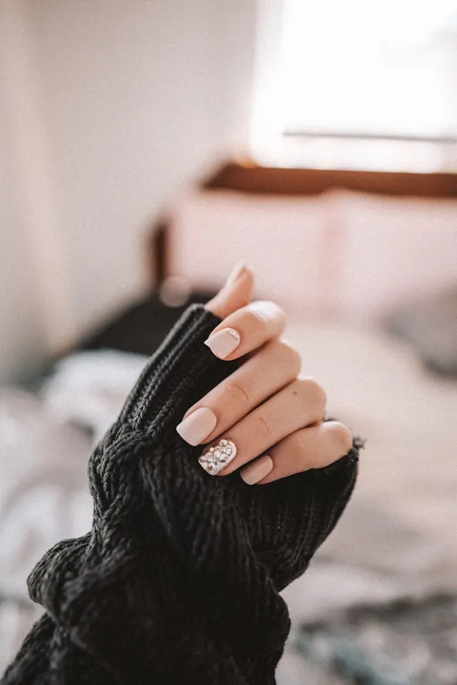 Cream-toned nails with delicate pearl accents for a timeless and refined look.