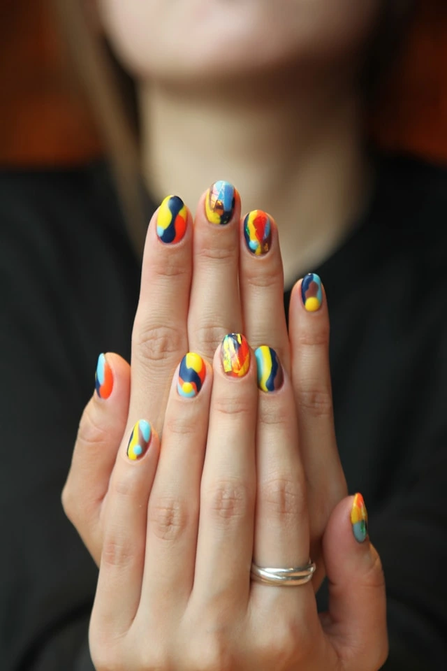 Vibrant, multi-colored nails with a trippy design — loud and unforgettable.